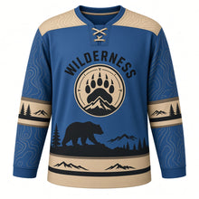 Load image into Gallery viewer, Black Bear Wilderness Original Hockey Jersey in Glacier Steel, front view – black bear on a rocky ridge with pines and paw-print crest, custom name and number