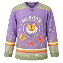 Load image into Gallery viewer, Butterfly Meadow Original Hockey Jersey in Lavender Field, front view – three butterflies over a wildflower meadow and butterfly-on-daisy crest, custom name and number