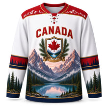Load image into Gallery viewer, Canada Rocky Mountain Majesty Original Hockey Jersey in Summit White, front view – alpenglow Rocky Mountain peaks over a turquoise glacier lake with a maple-leaf shield crest, custom name and number