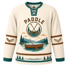 Load image into Gallery viewer, Canoe Mountain Lake Original Hockey Jersey in Campfire Cream, front view – wooden canoe with crossed paddles on a calm mountain lake with canoe crest, custom name and number