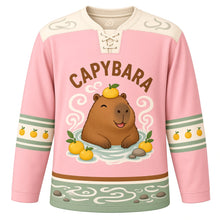 Load image into Gallery viewer, Capybara Hot Spring Original Hockey Jersey in Blossom Pink, front view – relaxed capybara soaking in a steaming hot spring with yuzu fruits and capybara crest, custom name and number