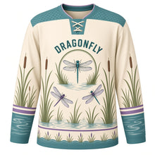 Load image into Gallery viewer, Dragonfly Marsh Original Hockey Jersey in Reed Cream, front view – dragonflies over marsh reeds and cattails with dragonfly crest, custom name and number