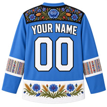 Load image into Gallery viewer, Estonia Original Hockey Jersey in Cornflower Blue, back view with your name and number – ornate Muhu floral embroidery yoke, Kihnu-stripe sleeve bands and rye-and-cornflower hem band, detailed artwork