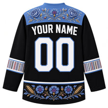 Load image into Gallery viewer, Estonia Original Hockey Jersey in Baltic Night Black, back view with your name and number – ornate Muhu floral embroidery yoke, Kihnu-stripe sleeve bands and rye-and-cornflower hem band, detailed artwork