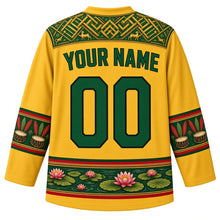 Load image into Gallery viewer, Guyana Original Hockey Jersey in Rupununi Gold, back view with your name and number – Amerindian basketry-weave yoke, steelpan-and-feather sleeve bands and Victoria lily hem, detailed artwork