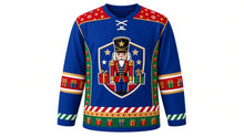 Load image into Gallery viewer, Ugly Christmas Nutcracker Hockey Jersey in Royal Blue, front view of a hockey jersey with royal blue body, red shoulder yoke printed with gold stars and candy stripes, emerald side panels with gold drums and blocks, red present-print elbow bands, candy stripe cuffs and a star and present hem stripe band, and a shield crest with a toy-soldier nutcracker, stars and wrapped presents on the chest, custom name and number