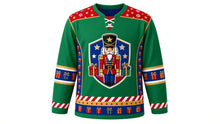 Load image into Gallery viewer, Ugly Christmas Nutcracker Hockey Jersey in Emerald, front view of a hockey jersey with emerald green body, red shoulder yoke printed with gold stars and candy stripes, royal blue side panels with gold drums and blocks, blue present-print elbow bands, red candy stripe cuffs and a star and present hem stripe band, and a shield crest with a toy-soldier nutcracker, stars and wrapped presents on the chest, custom name and number