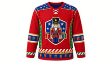 Load image into Gallery viewer, Ugly Christmas Nutcracker Hockey Jersey in Toy Soldier Red, front view of a hockey jersey with toy soldier red body, royal blue shoulder yoke printed with gold stars and candy stripes, emerald side panels with gold drums and blocks, blue present-print elbow bands, candy stripe cuffs and a star and present hem stripe band, and a shield crest with a toy-soldier nutcracker, stars and wrapped presents on the chest, custom name and number