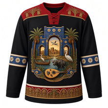 Load image into Gallery viewer, Iraq Original Hockey Jersey in Basalt Black, front view – ornate Babylonian glazed-brick gate crest with mudhif reed house, water buffalo and date palms and woven palm-frond and date-cluster yoke, detailed artwork, custom name and number