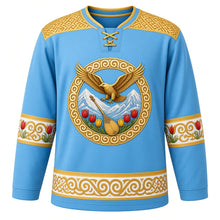 Load image into Gallery viewer, Kazakhstan Original Hockey Jersey in Steppe Sky Blue, front view – ornate golden eagle over Tian Shan peaks crest with dombra and wild tulips, qoshqar muiiz ram's-horn felt yoke, detailed illustrated artwork, custom name and number