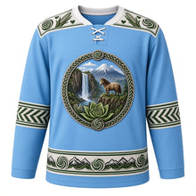 Load image into Gallery viewer, Lesotho Original Hockey Jersey in Maloti Sky Blue, front view – Maletsunyane Falls, Mount Qiloane and Basotho pony crest with spiral aloe, Basotho blanket-pattern yoke and woven-grass sleeve bands, ornate detailed artwork, custom name and number
