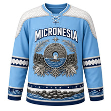 Load image into Gallery viewer, Micronesia Original Hockey Jersey in Pacific Blue, front view – ornate rai stone crest with outrigger canoe and woven pandanus yoke, detailed artwork, custom name and number
