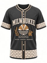 Load image into Gallery viewer, Milwaukee Original Baseball Jersey in Charcoal, front view – charcoal body with cream brick trim, Cream City brick trim, Lake Michigan sunrise emblem with barley and hops, and a RACINE • KENOSHA • WAUKESHA city line – custom name and number