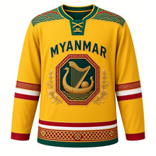 Load image into Gallery viewer, Myanmar Original Hockey Jersey in Padauk Yellow, front view – acheik wave-silk yoke and lacquerware saung gauk harp crest with ornate detailed artwork, custom name and number