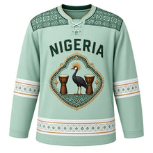 Load image into Gallery viewer, Nigeria Original Hockey Jersey in Palm Mint, front view – adire-pattern yoke and diamond crowned-crane Zuma Rock crest in ornate detailed artwork, custom name and number