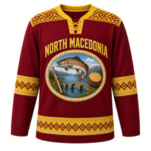 Load image into Gallery viewer, North Macedonia Original Hockey Jersey in Ohrid Wine Red, front view – folk cross-stitch embroidery yoke and pearl-ringed Lake Ohrid trout crest in ornate detailed artwork, custom name and number