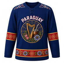 Load image into Gallery viewer, Paraguay Original Hockey Jersey in Itaugua Blue, front view – ñandutí lace harp crest and ao po'i embroidery yoke with ornate detailed artwork, custom name and number