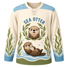 Load image into Gallery viewer, Sea Otter Kelp Forest Original Hockey Jersey in Sea Foam Cream, front view – sea otter floating among kelp with a seashell and sea-otter crest, custom name and number