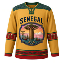 Load image into Gallery viewer, Senegal Original Hockey Jersey in Sahel Gold, front view – baobab and painted-pirogue cartouche crest under SENEGAL lettering, ornate indigo-pattern yoke and detailed artwork, custom name and number