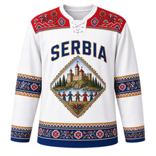 Load image into Gallery viewer, Serbia Original Hockey Jersey in Kolo White, front view – Golubac Fortress and kolo-dancer diamond crest under SERBIA lettering, ornate Pirot kilim yoke and detailed artwork, custom name and number