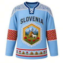 Load image into Gallery viewer, Slovenia Original Hockey Jersey in Ljubljana Sky, front view – Idrija lace yoke and honeycomb crest with Lipizzaner horse, kozolec hayrack and honey bees, ornate detailed artwork, custom name and number