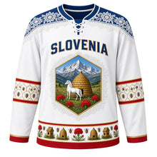 Load image into Gallery viewer, Slovenia Original Hockey Jersey in Alpine White, front view – Idrija lace yoke and honeycomb crest with Lipizzaner horse, kozolec hayrack and honey bees, ornate detailed artwork, custom name and number