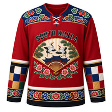 Load image into Gallery viewer, South Korea Original Hockey Jersey in Dancheong Red, front view – dancheong yoke and folding-fan crane and mugunghwa crest with ornate detailed artwork, custom name and number