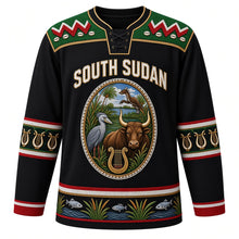 Load image into Gallery viewer, South Sudan Original Hockey Jersey in Cattle Camp Black, front view – ornate beaded oval crest with long-horned bull, shoebill and kob, Dinka beadwork yoke, detailed artwork, custom name and number