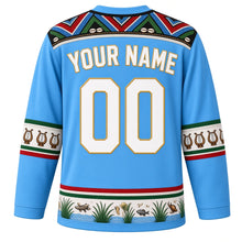 Load image into Gallery viewer, South Sudan Original Hockey Jersey in White Nile Blue, back view with your name and number – Dinka beadwork yoke and cattle-horn sleeve bands