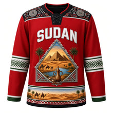 Load image into Gallery viewer, Sudan Original Hockey Jersey in Nubian Red, front view – ornate pyramid-shaped crest with Meroe pyramids, camel caravan and Nile confluence, Nubian painted yoke, detailed artwork, custom name and number