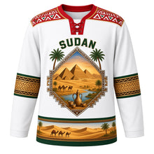 Load image into Gallery viewer, Sudan Original Hockey Jersey in Nile White, front view – ornate pyramid-shaped crest with Meroe pyramids, camel caravan and Nile confluence, Nubian painted yoke, detailed artwork, custom name and number