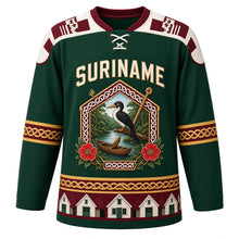 Load image into Gallery viewer, Suriname Original Hockey Jersey in Rainforest Green, front view – ornate gabled tembe-carved crest with rainforest canoe, kiskadee and faya lobi flowers, pangi yoke, detailed artwork, custom name and number