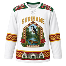 Load image into Gallery viewer, Suriname Original Hockey Jersey in Paramaribo White, front view – ornate gabled tembe-carved crest with rainforest canoe, kiskadee and faya lobi flowers, pangi yoke, detailed artwork, custom name and number