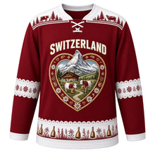 Load image into Gallery viewer, Switzerland Original Hockey Jersey in Alpenglow Crimson, front view – ornate heart-shaped papercut crest with Matterhorn, chalet, cowbells and alphorns, detailed artwork, custom name and number