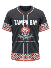 Load image into Gallery viewer, Tampa Bay Original Baseball Jersey in Charcoal, front view – charcoal body with coral and white piping, Ybor City-style mosaic tile trim, Gulf sunset palm emblem and a ST. PETERSBURG • CLEARWATER • YBOR CITY city line – custom name and number