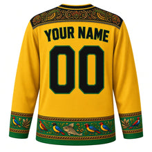 Load image into Gallery viewer, Tanzania Original Hockey Jersey in Clove Gold, back view with your name and number – kanga-border yoke and Tingatinga bird sleeve bands