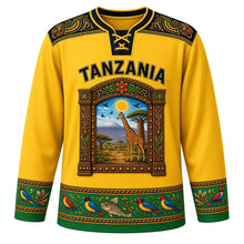 Load image into Gallery viewer, Tanzania Original Hockey Jersey in Clove Gold, front view – ornate Zanzibar carved-door crest with Kilimanjaro and giraffe in Tingatinga style, detailed artwork, custom name and number