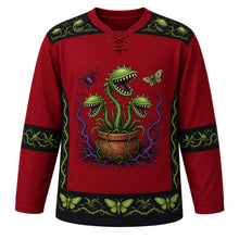 Load image into Gallery viewer, Ugly Halloween Carnivorous Plant Garden Hockey Jersey in Blood Moon Red, front view – blood moon red body with black and green trim with a crest of snapping carnivorous flytrap plants with jagged teeth and glowing eyes in a clay pot ringed by thorny vines, a spider and a moth, flytrap-and-thorn yoke and moth-patterned stripe bands – custom name and number