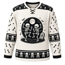 Load image into Gallery viewer, Ugly Halloween Rattling Skeletons Hockey Jersey in Bone White, front view – bone white body with black yoke with a round dancing-skeletons crest with full moon, skulls, crossed bones, bats and a tombstone, skull yoke, bone sleeve bands and a skull hem band – custom name and number