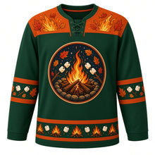 Load image into Gallery viewer, Ugly Thanksgiving Autumn Bonfire Night Hockey Jersey in Spruce Green, front view – round crest of a campfire in a stone ring under a starry night sky with marshmallows on sticks and autumn leaves, orange yoke of flames and leaves, marshmallow-on-stick and leaf sleeve bands and a hem of mini campfires alternating with marshmallows – custom name and number