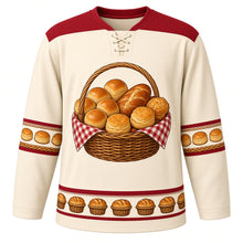 Load image into Gallery viewer, Ugly Thanksgiving Harvest Bread Basket Hockey Jersey in Wheat Cream, front view – wheat cream body with cranberry red yoke with a round crest of an overflowing woven wicker basket lined with red gingham and piled with golden dinner rolls, a braided loaf and flaky biscuits, basket-weave yoke, biscuit and braided-twist sleeve bands and a mini bread-basket hem band – custom name and number
