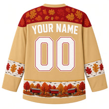 Load image into Gallery viewer, Ugly Thanksgiving Covered Bridge Foliage Hockey Jersey in Birch Gold, back view – birch gold body with barn red oak-leaf yoke, birch-bark sleeve bands with oak leaves, a hem band of little red covered bridges among fall trees, straight YOUR NAME lettering and 00 – custom name and number