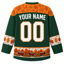 Load image into Gallery viewer, Ugly Thanksgiving Covered Bridge Foliage Hockey Jersey in Hemlock Green, back view – hemlock green body with foliage orange oak-leaf yoke, birch-bark sleeve bands with oak leaves, a hem band of little red covered bridges among fall trees, straight YOUR NAME lettering and 00 – custom name and number