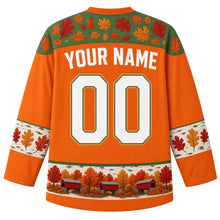 Load image into Gallery viewer, Ugly Thanksgiving Covered Bridge Foliage Hockey Jersey in Foliage Orange, back view – foliage orange body with hemlock green oak-leaf yoke, birch-bark sleeve bands with oak leaves, a hem band of little red covered bridges among fall trees, straight YOUR NAME lettering and 00 – custom name and number