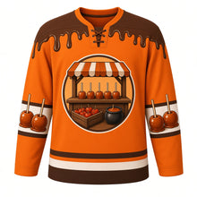 Load image into Gallery viewer, Ugly Thanksgiving Caramel Apple Stand Hockey Jersey in Pumpkin Orange, front view – pumpkin orange body with barnwood brown yoke with a round crest of a rustic wooden farm stand with a striped awning and a counter of glossy caramel apples on sticks, a crate of apples and a caramel pot, caramel-drip yoke, caramel-apple sleeve bands and a caramel-apple-and-crate hem band – custom name and number