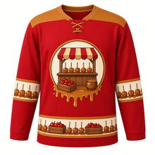 Load image into Gallery viewer, Ugly Thanksgiving Caramel Apple Stand Hockey Jersey in Candy Apple Red, front view – candy apple red body with caramel gold yoke with a round crest of a rustic wooden farm stand with a striped awning and a counter of glossy caramel apples on sticks, a crate of apples and a caramel pot, caramel-drip yoke, caramel-apple sleeve bands and a caramel-apple-and-crate hem band – custom name and number