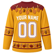 Load image into Gallery viewer, Ugly Thanksgiving Gratitude Leaf Garland Hockey Jersey in Goldenrod, back view with a twine garland of oval leaves and acorns with clothespins over the yoke, matching leaf-and-acorn sleeve bands, a hem band of acorns, red berries and leaves, arched YOUR NAME lettering and 00 – custom name and number