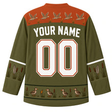 Load image into Gallery viewer, Ugly Thanksgiving Goose Flock Migration Hockey Jersey in Cattail Olive, back view – cattail olive body with rust orange yoke with a row of five flying geese and little cattails, cattail-and-feather sleeve bands, a hem band of goslings among cattails, straight YOUR NAME lettering and 00 – custom name and number