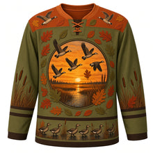 Load image into Gallery viewer, Ugly Thanksgiving Goose Flock Migration Hockey Jersey in Cattail Olive, front view – cattail olive body with rust orange yoke, a round sunset marsh crest with five flying geese ringed by oak and oval leaves, a yoke with two flying geese and leaves, cattails on the sleeves and a hem band of geese waddling among cattails at the water – custom name and number