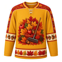 Load image into Gallery viewer, Ugly Thanksgiving Autumn Leaf Pile Hockey Jersey in Mustard Yellow, front view – mustard yellow body with maple red yoke with a round crest of a towering autumn leaf pile with a wooden rake, acorns and pinecones, swirling-leaf yoke, acorn and pinecone sleeve bands and a leaf-pile hem band – custom name and number